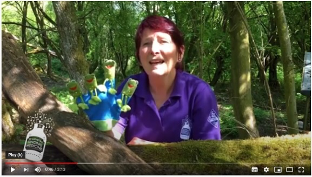 woman singing in a forest with a glove puppet