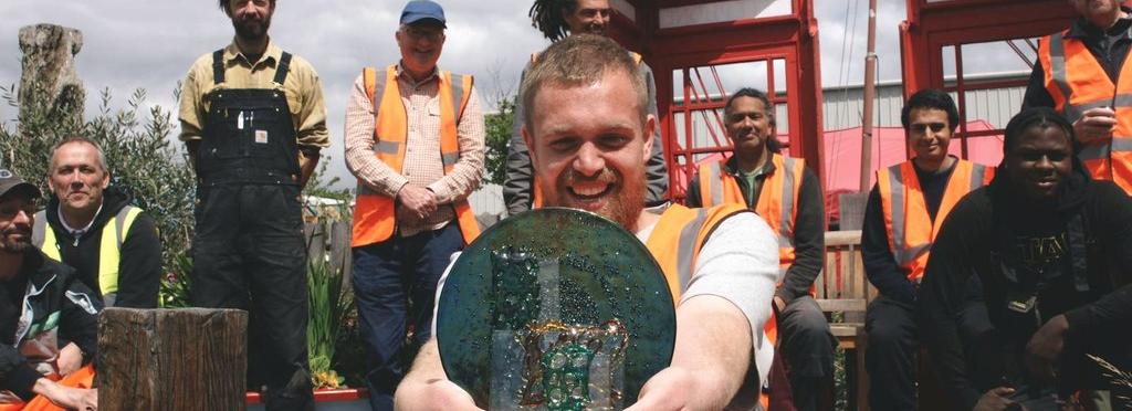 Cody Dock team members in high-vis jackets show off their glass CHWA Award made by Stevie Davies