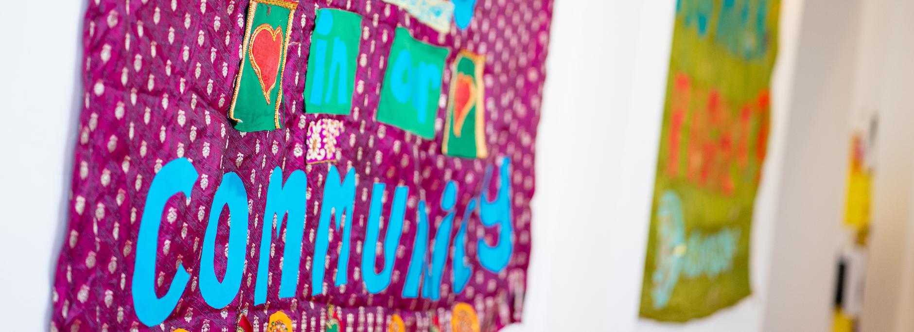 An image of banners on a wall, the nearest one reads 'unity in community'