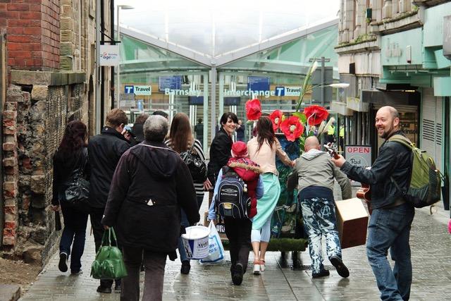 A photo of some people walking towards Barnsley Station with art