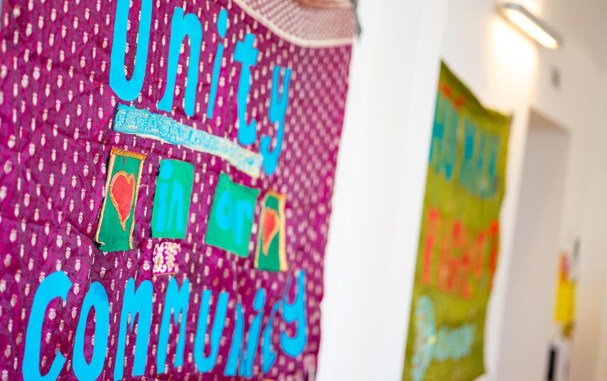 An image of banners on a wall, the nearest one reads 'unity in community'