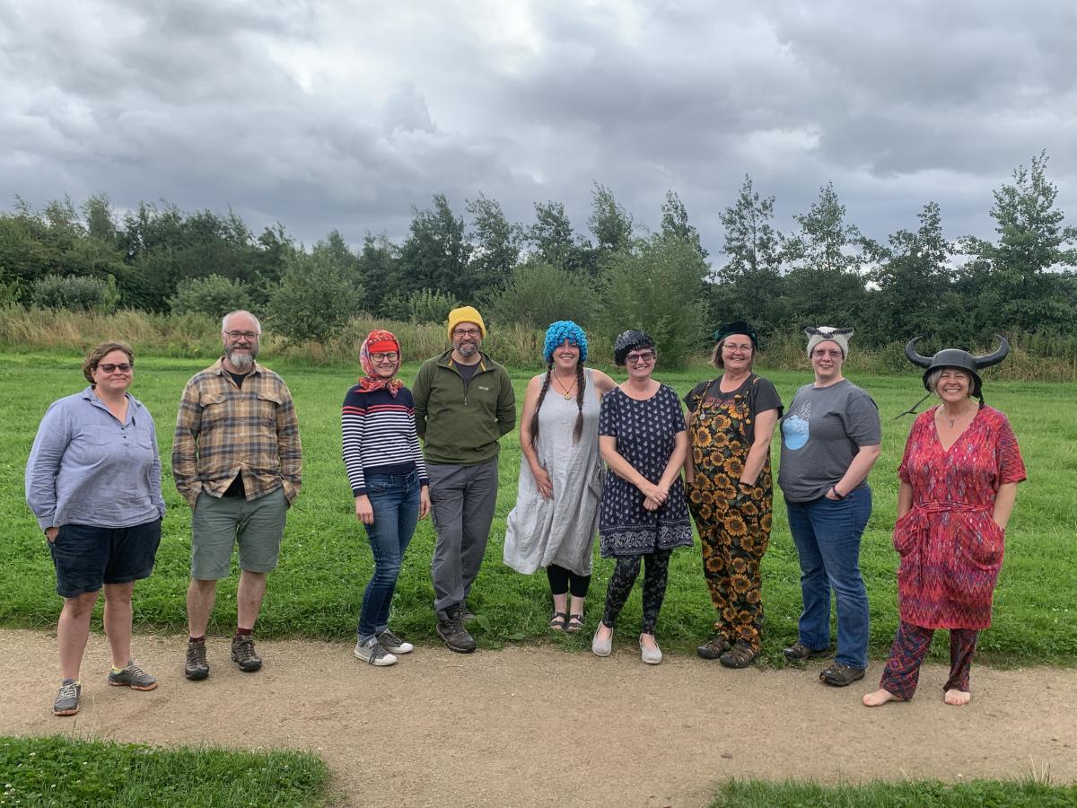 People wearing different coloured hats stand in a line outdoors