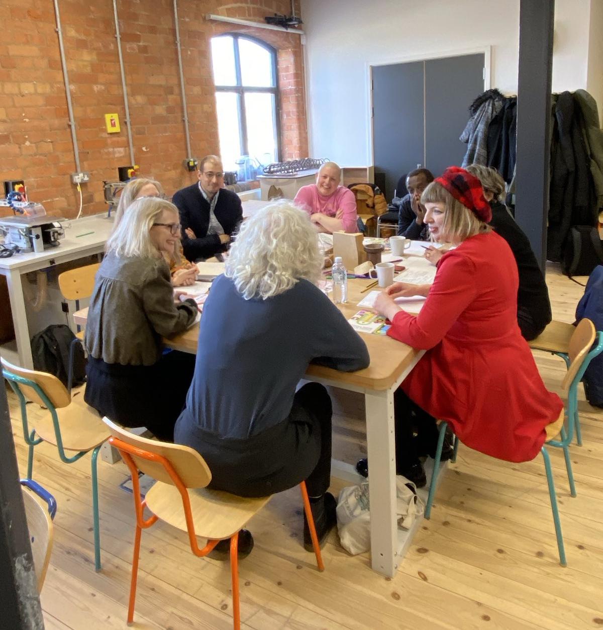 a group of people sit at a table talking