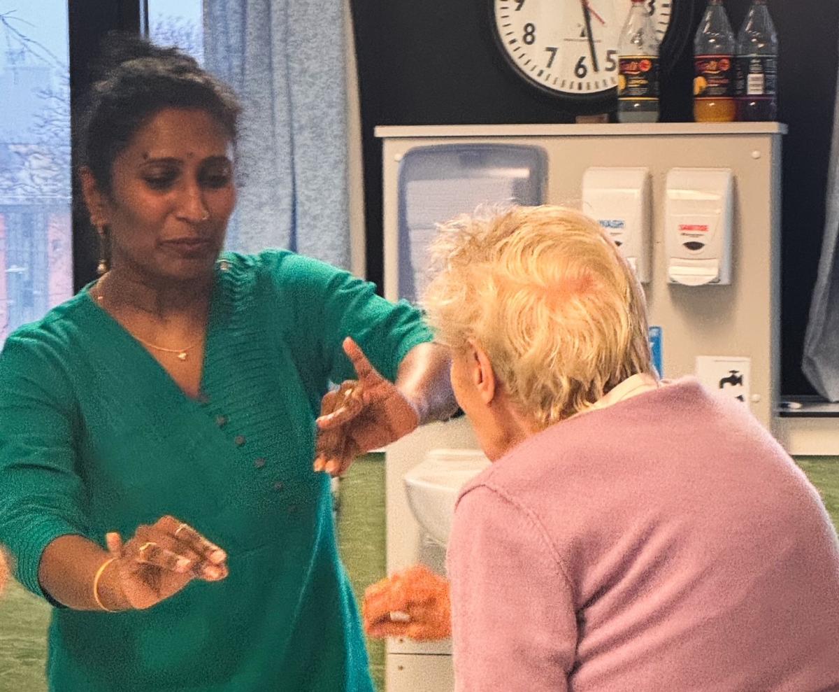 Photo of one woman teaching another to dance
