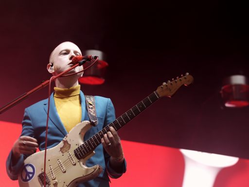 A photograph of a performer singing and holding a guitar at Tramlines 2019; Dan Bale, Open House Pictures