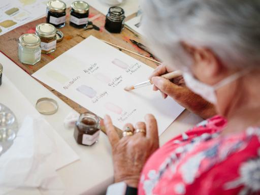 Woman completing watercolour with a mask on 