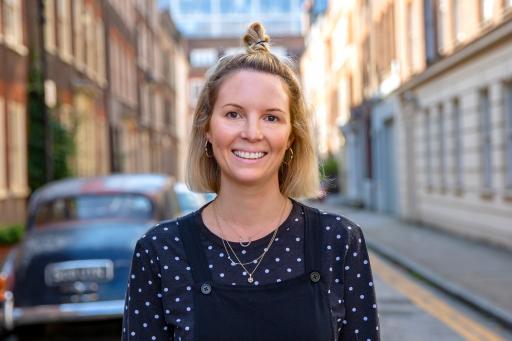 portrait of Anna Woolf wearing a black and white top in a London street