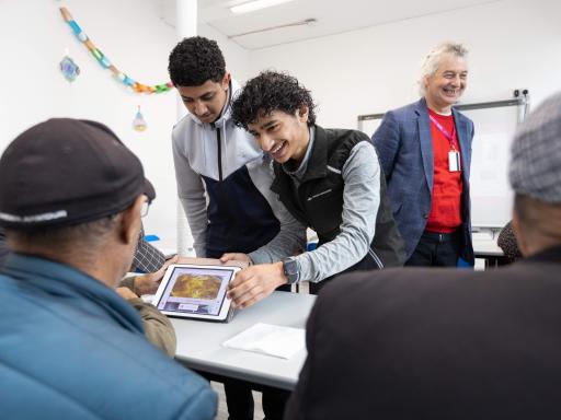 Young members of the Yemeni community in Liverpool sharing new app with elders in a classroom setting