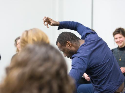 Man moving with clenched hand in forward motion with observers