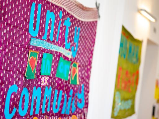 An image of banners on a wall, the nearest one reads 'unity in community'