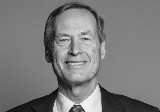 black and white head-and-shoulders photograph of a man looking straight at the camera and smiling