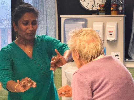 Photo of one woman teaching another to dance