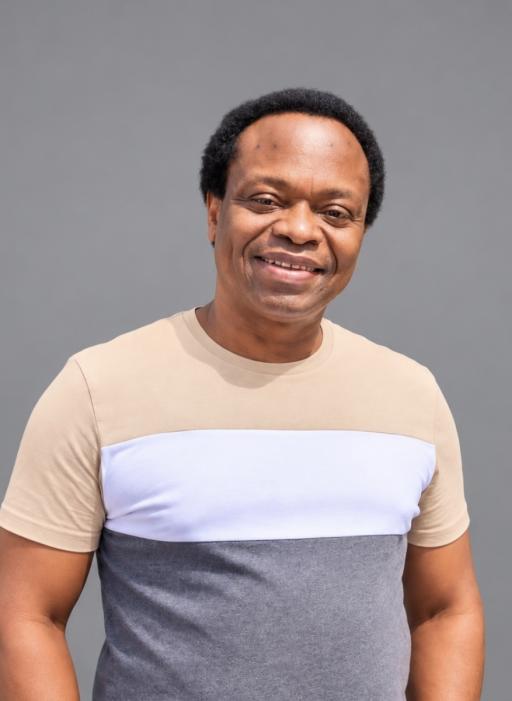 A black man with a low afro wearing a beige, white and grey striped t-shirt smiling at the camera